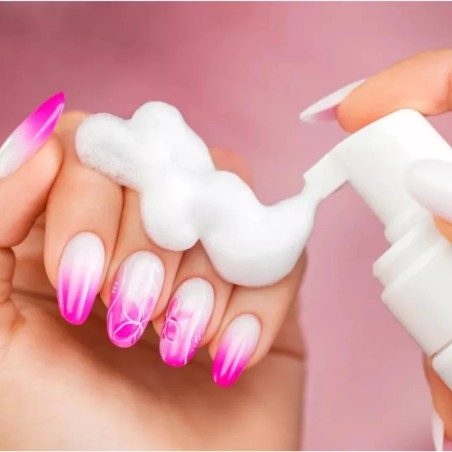 Aplicación de espuma limpiadora sobre las uñas y manos durante la manicura