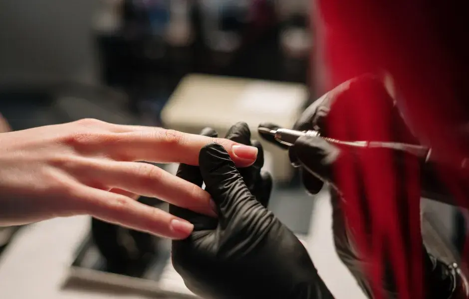 manicurista trabajando con torno y fresas de manicura